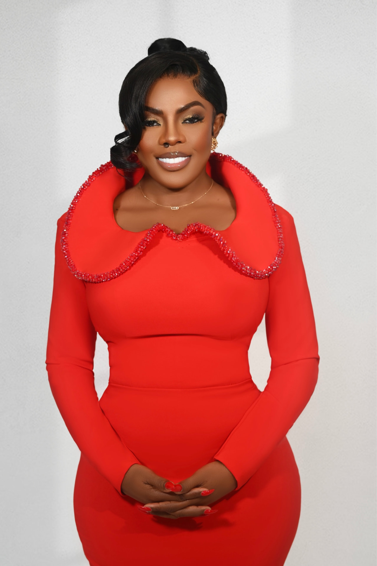 Nana Aba Anamoah smiling in a red dress